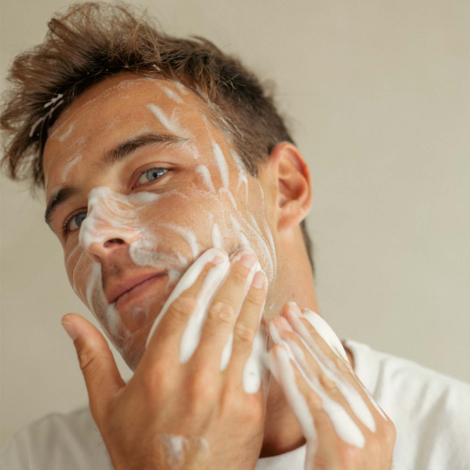 male cleaning his face with foaming face wash